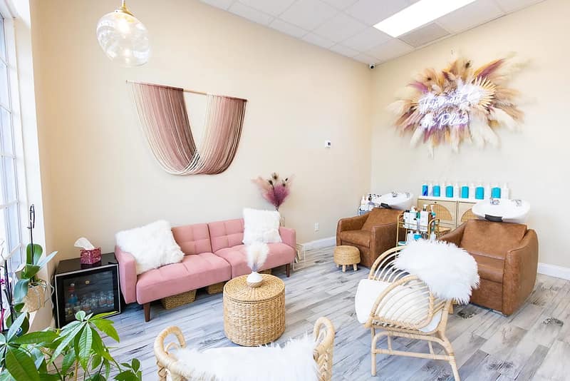 The warm, boho-chic waiting area inside The Glam Room in Wellington, Florida