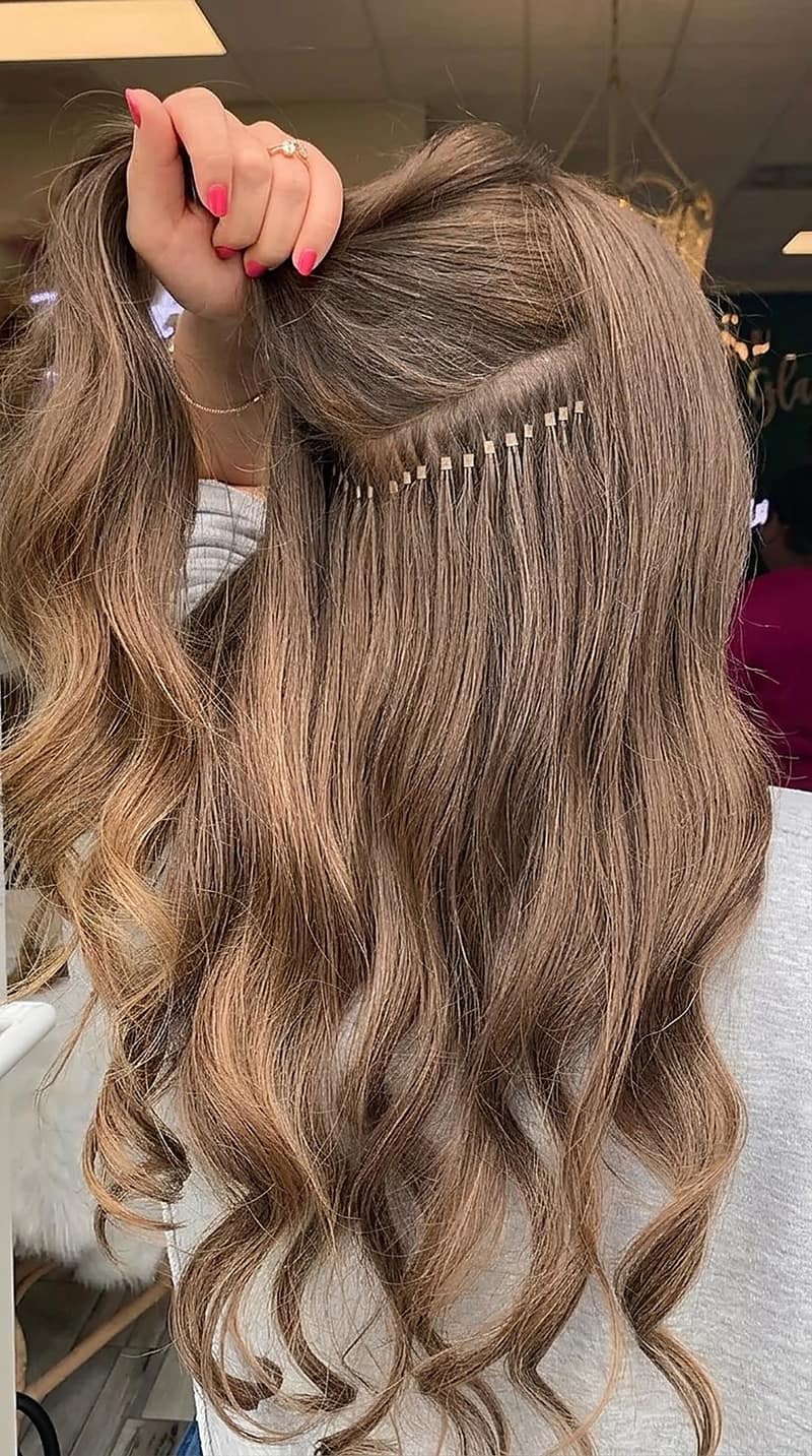 K-tip keratin bonds being applied to brown hair